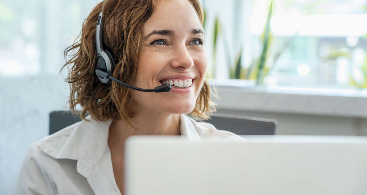 Lachende Dame aus dem Call Center mit Mikrofon und Kopfhören. 